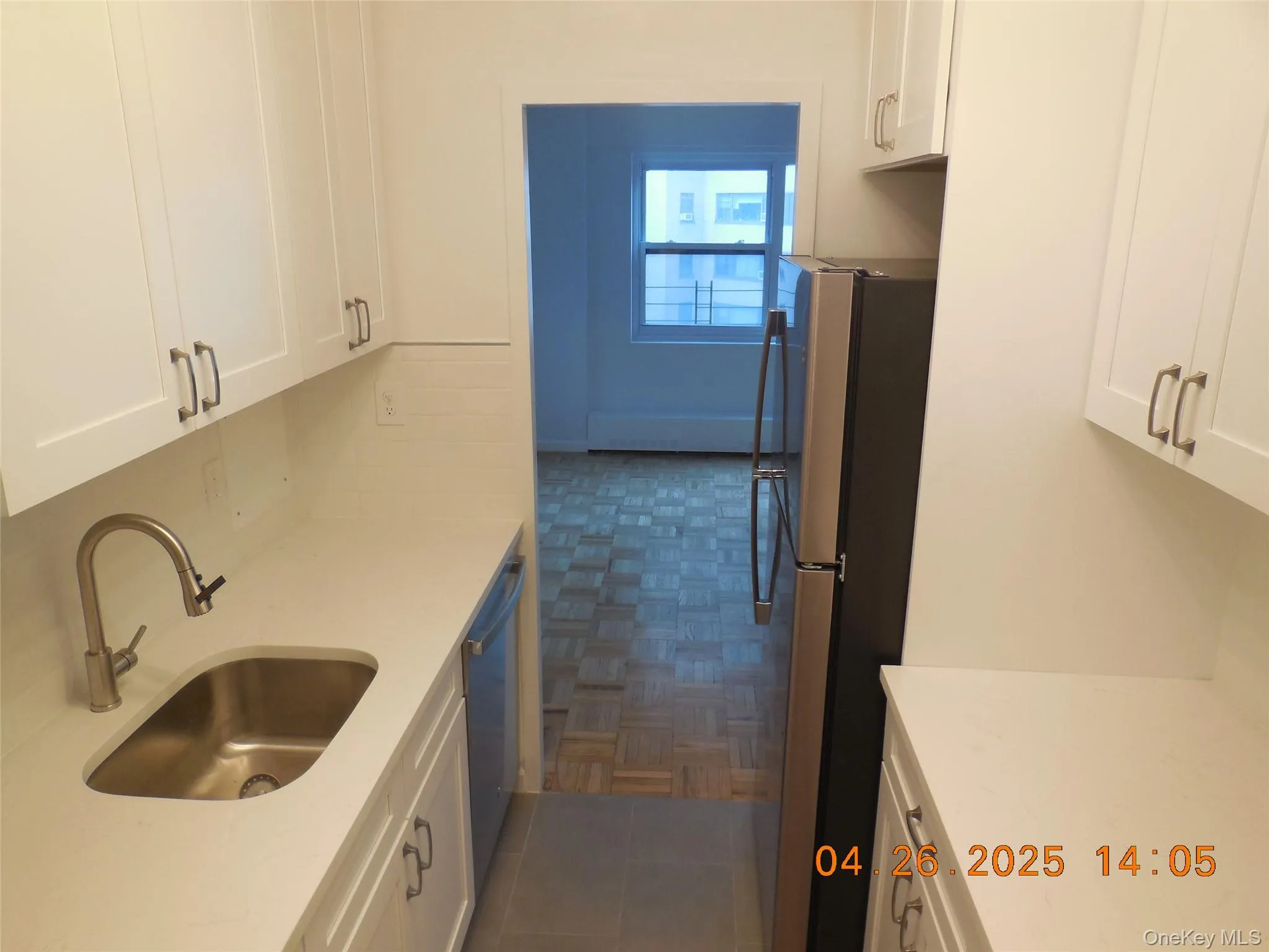Kitchen featuring a sink, appliances with stainless steel finishes, white cabinetry, and light countertops Kitchen featuring a sink, appliances with stainless steel finishes, white cabinetry, and light countertops