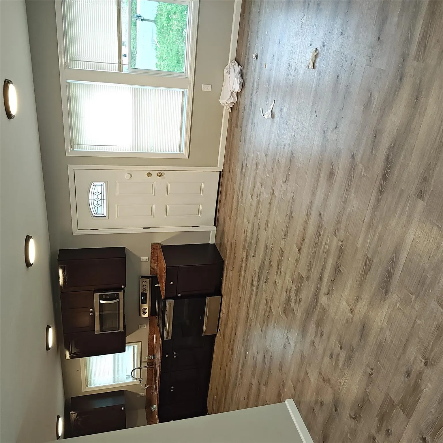 Kitchen with stove, a sink, baseboards, and light wood finished floors Kitchen with stove, a sink, baseboards, and light wood finished floors