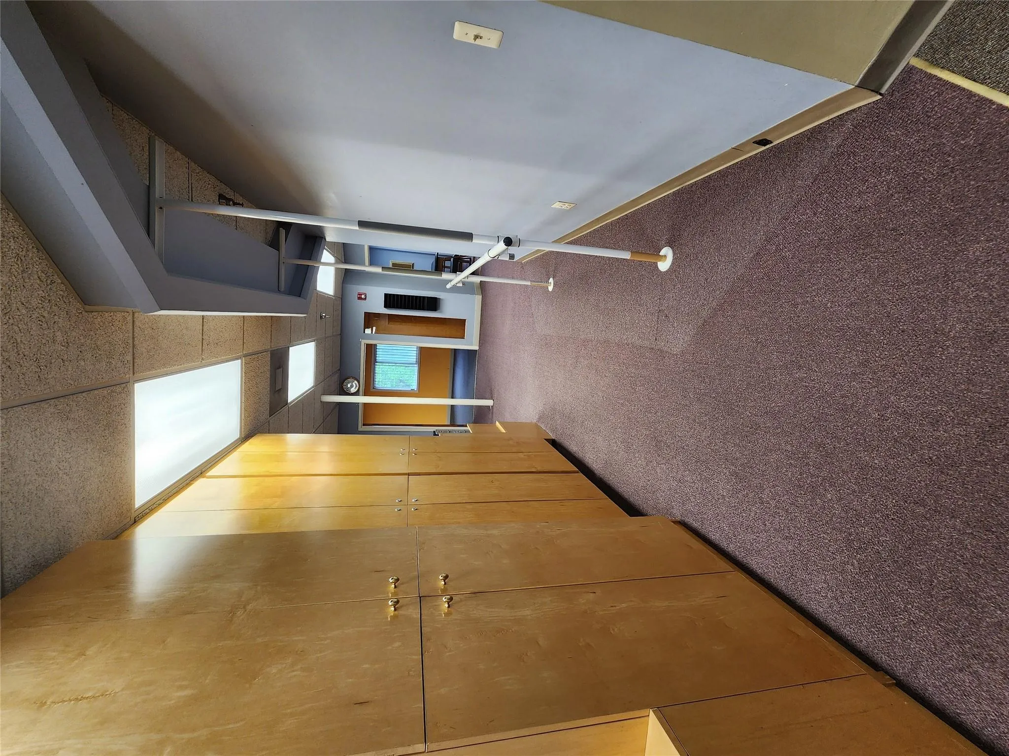 Hallway featuring a paneled ceiling, carpet floors, and baseboards Hallway featuring a paneled ceiling, carpet floors, and baseboards