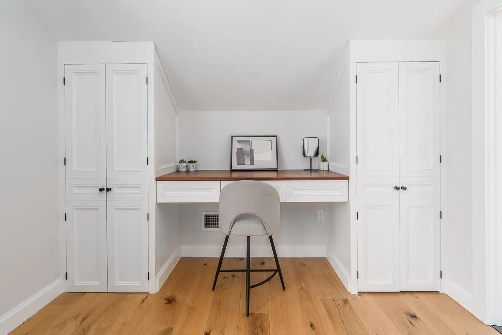 Office area with built in study area, light wood finished floors, and baseboards Office area with built in study area, light wood finished floors, and baseboards