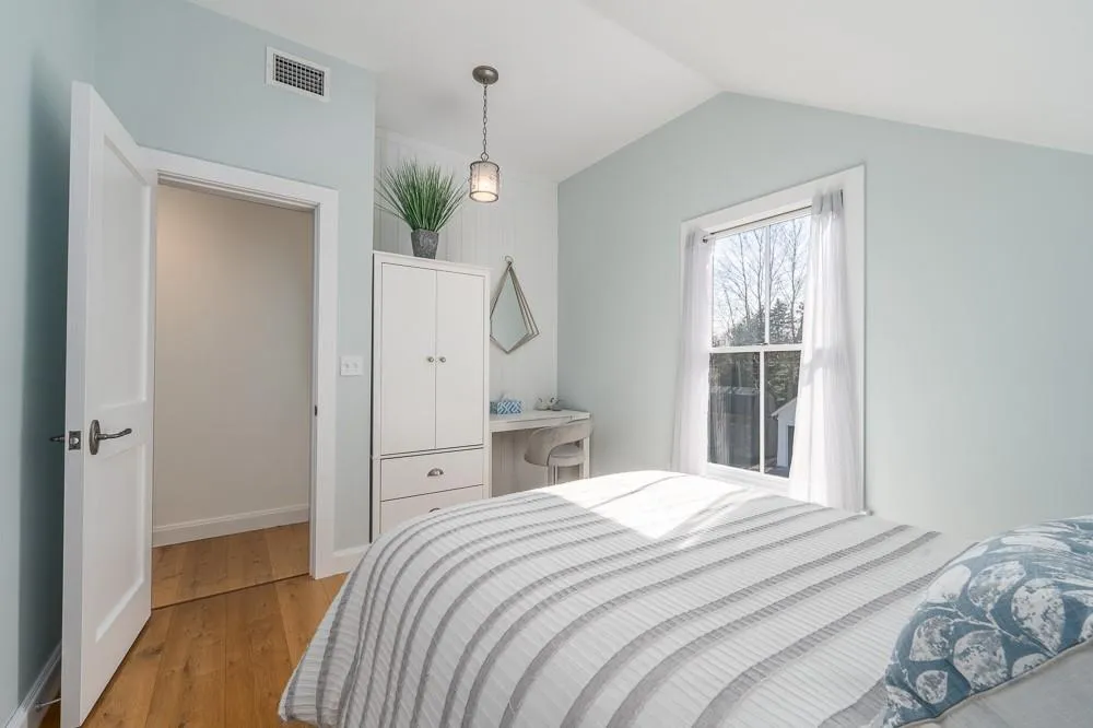 Bedroom with light wood-style flooring, lofted ceiling, and baseboards Bedroom with light wood-style flooring, lofted ceiling, and baseboards