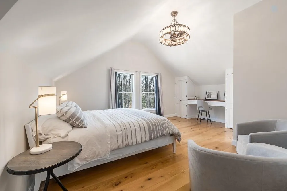 Bedroom with light wood-style floors, lofted ceiling, a chandelier, baseboards, and a desk Bedroom with light wood-style floors, lofted ceiling, a chandelier, baseboards, and a desk