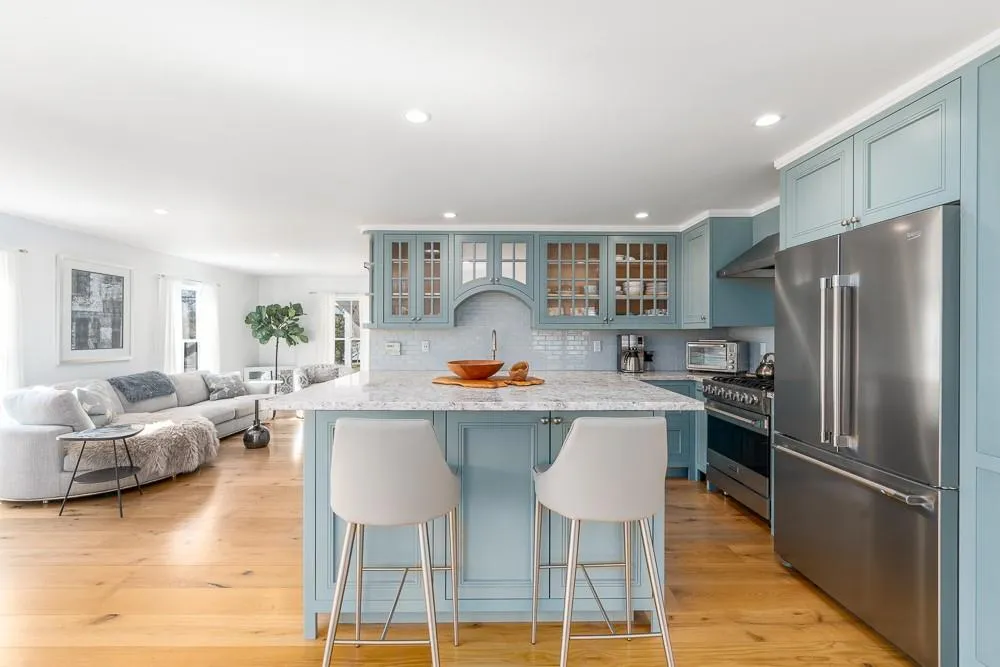 Kitchen with premium appliances, wall chimney exhaust hood, a kitchen breakfast bar, decorative backsplash, and recessed lighting Kitchen with premium appliances, wall chimney exhaust hood, a kitchen breakfast bar, decorative backsplash, and recessed lighting