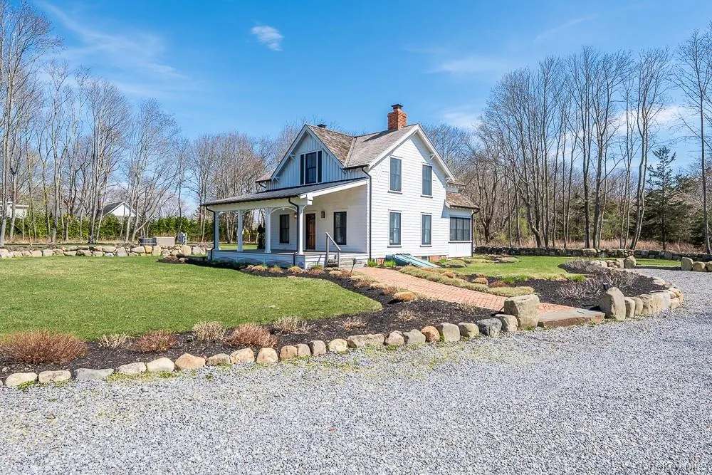 View of home's exterior featuring a chimney, covered porch, a lawn, and a shingled roof View of home's exterior featuring a chimney, covered porch, a lawn, and a shingled roof