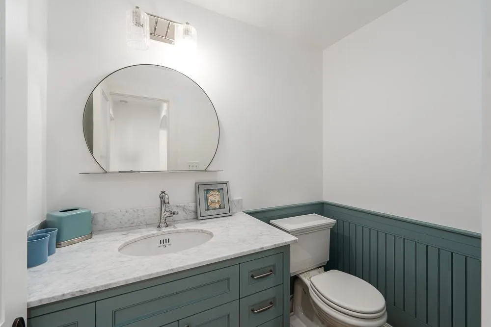 Half bath with a wainscoted wall, toilet, and vanity Half bath with a wainscoted wall, toilet, and vanity