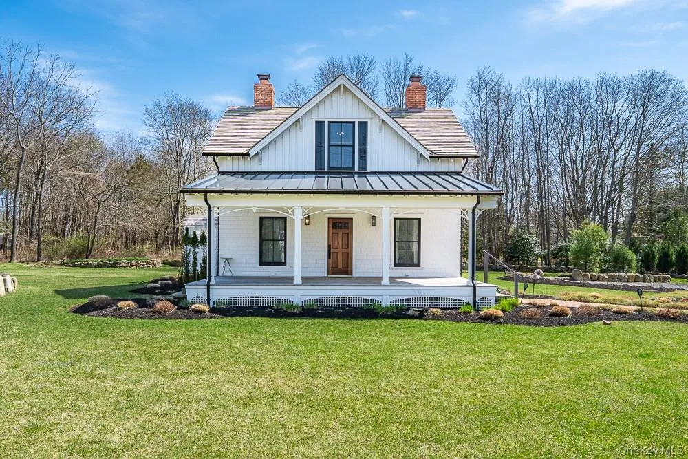 Modern farmhouse style home with a standing seam roof, a porch, a chimney, a front yard, and metal roof Modern farmhouse style home with a standing seam roof, a porch, a chimney, a front yard, and metal roof