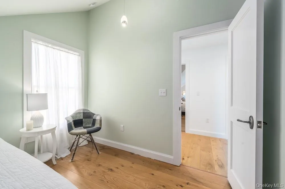 Bedroom with wood finished floors, lofted ceiling, and baseboards Bedroom with wood finished floors, lofted ceiling, and baseboards