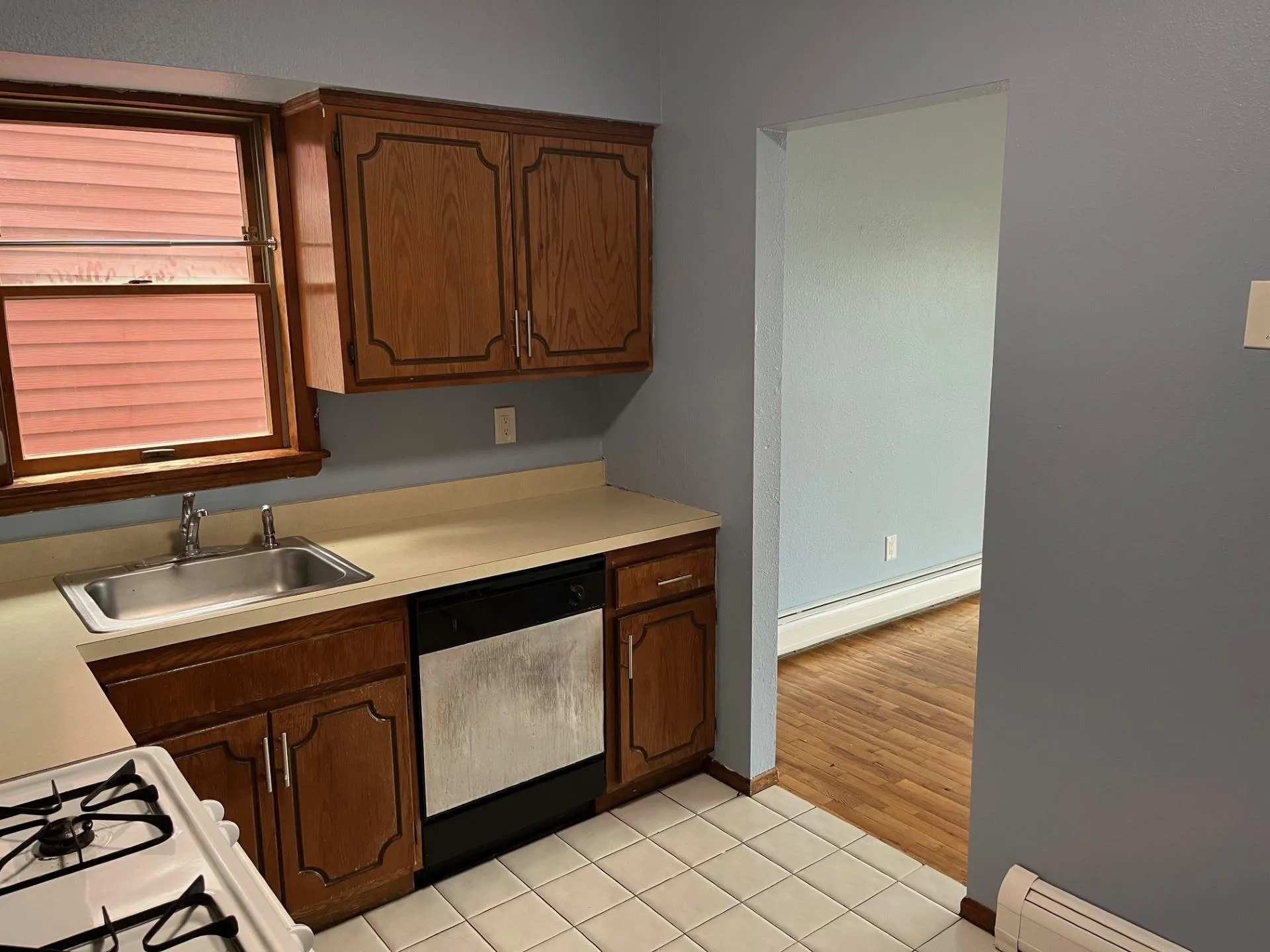 Kitchen with dishwasher, a baseboard radiator, light countertops, and light tile patterned floors Kitchen with dishwasher, a baseboard radiator, light countertops, and light tile patterned floors