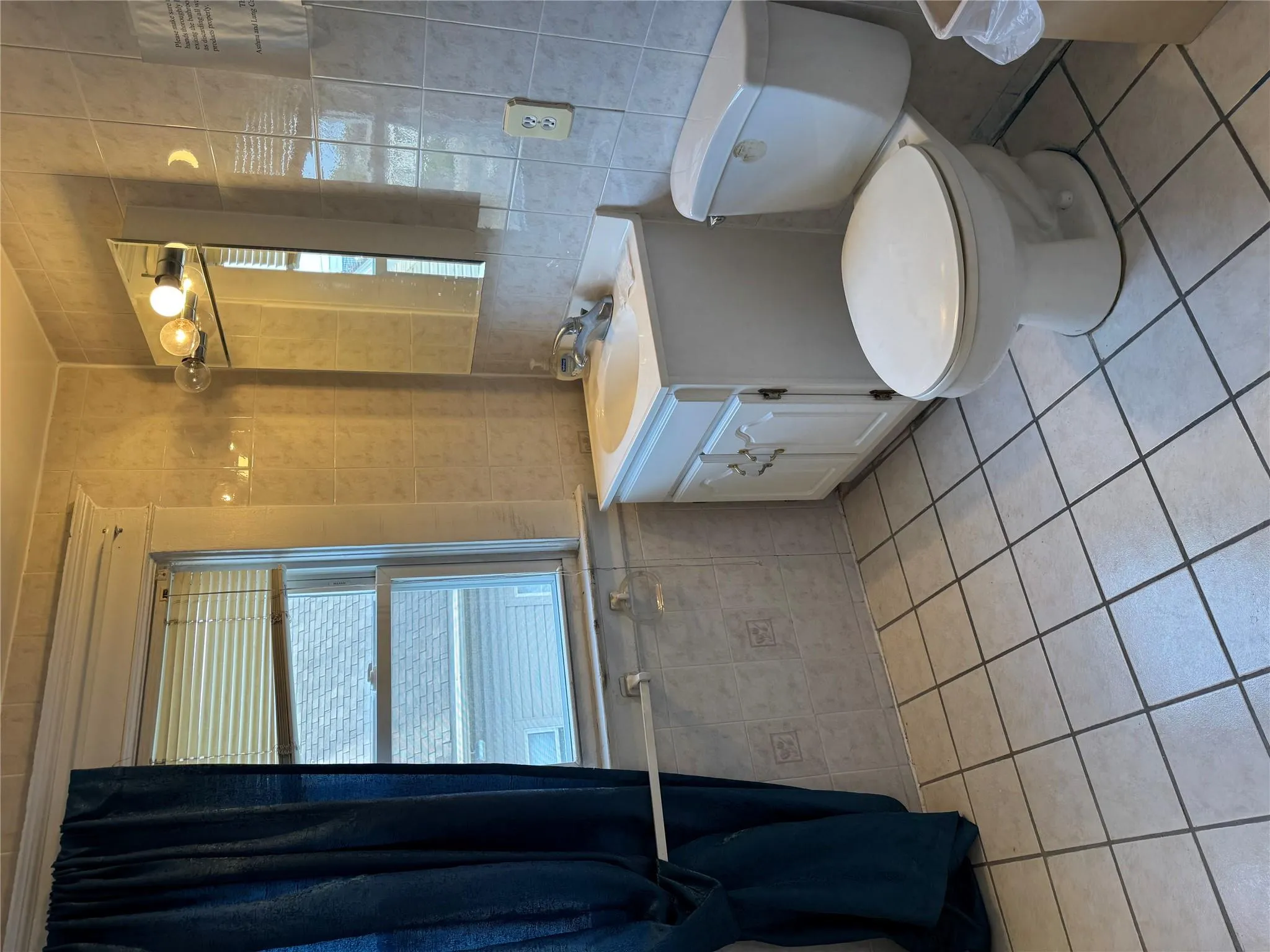 Bathroom with tile walls, tile patterned flooring, toilet, and vanity Bathroom with tile walls, tile patterned flooring, toilet, and vanity