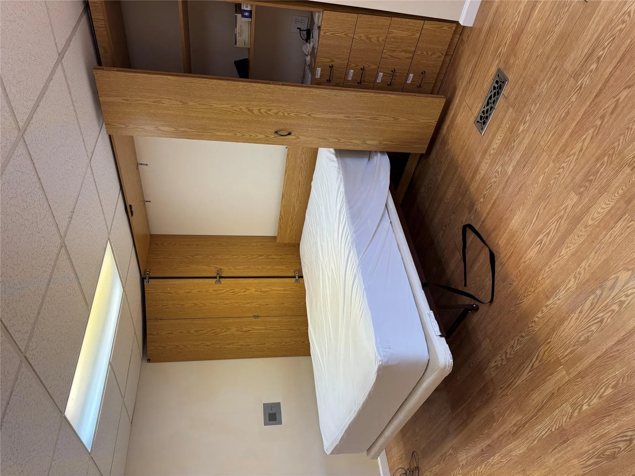 Bedroom with light wood finished floors, a drop ceiling, and baseboards Bedroom with light wood finished floors, a drop ceiling, and baseboards