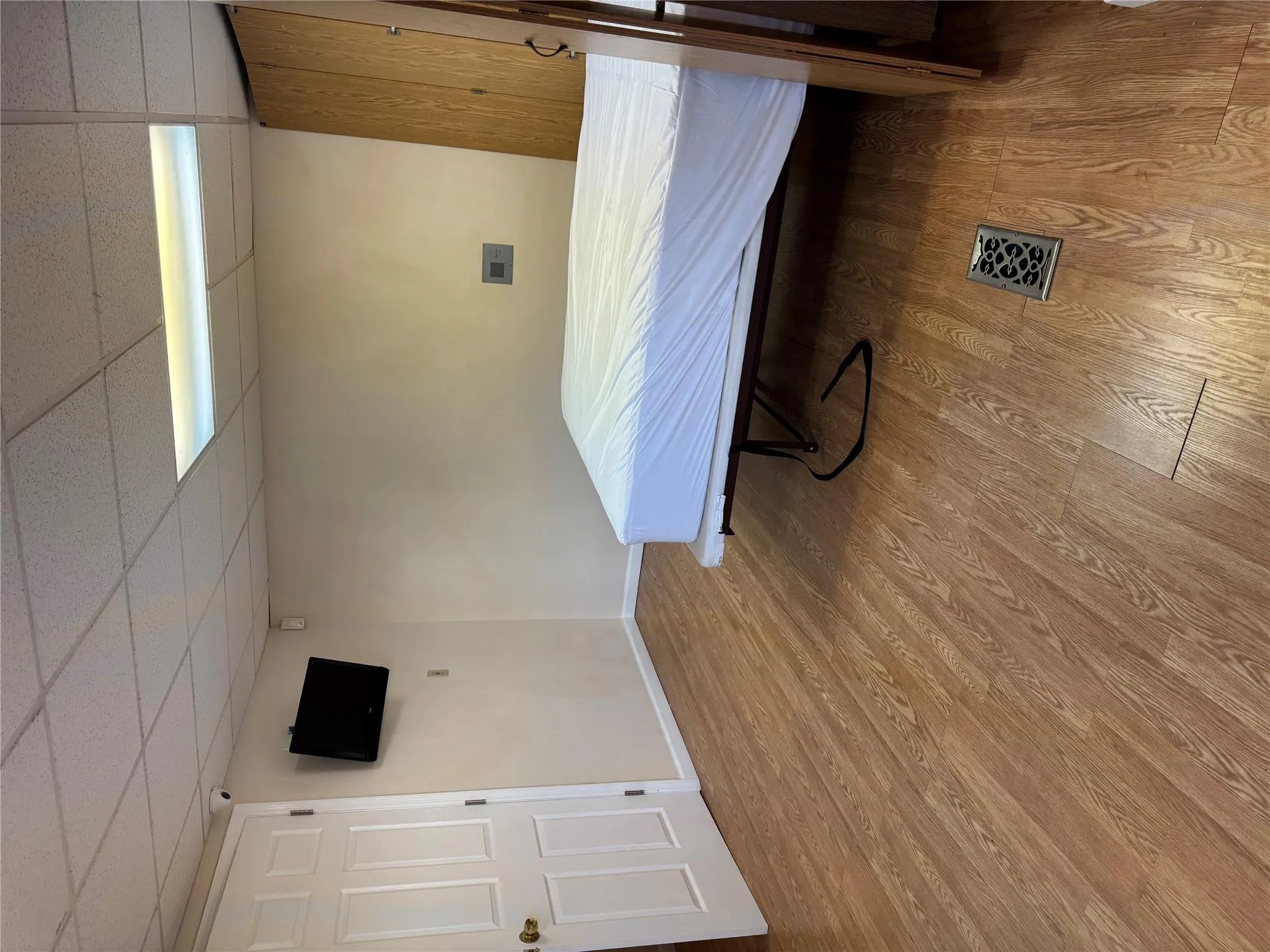 Bedroom with a paneled ceiling, wood finished floors, and baseboards Bedroom with a paneled ceiling, wood finished floors, and baseboards