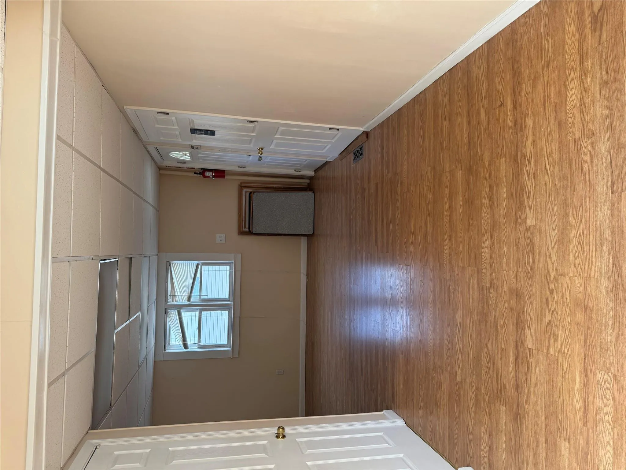 Below grade area with a paneled ceiling, light wood-style floors, and baseboards Below grade area with a paneled ceiling, light wood-style floors, and baseboards