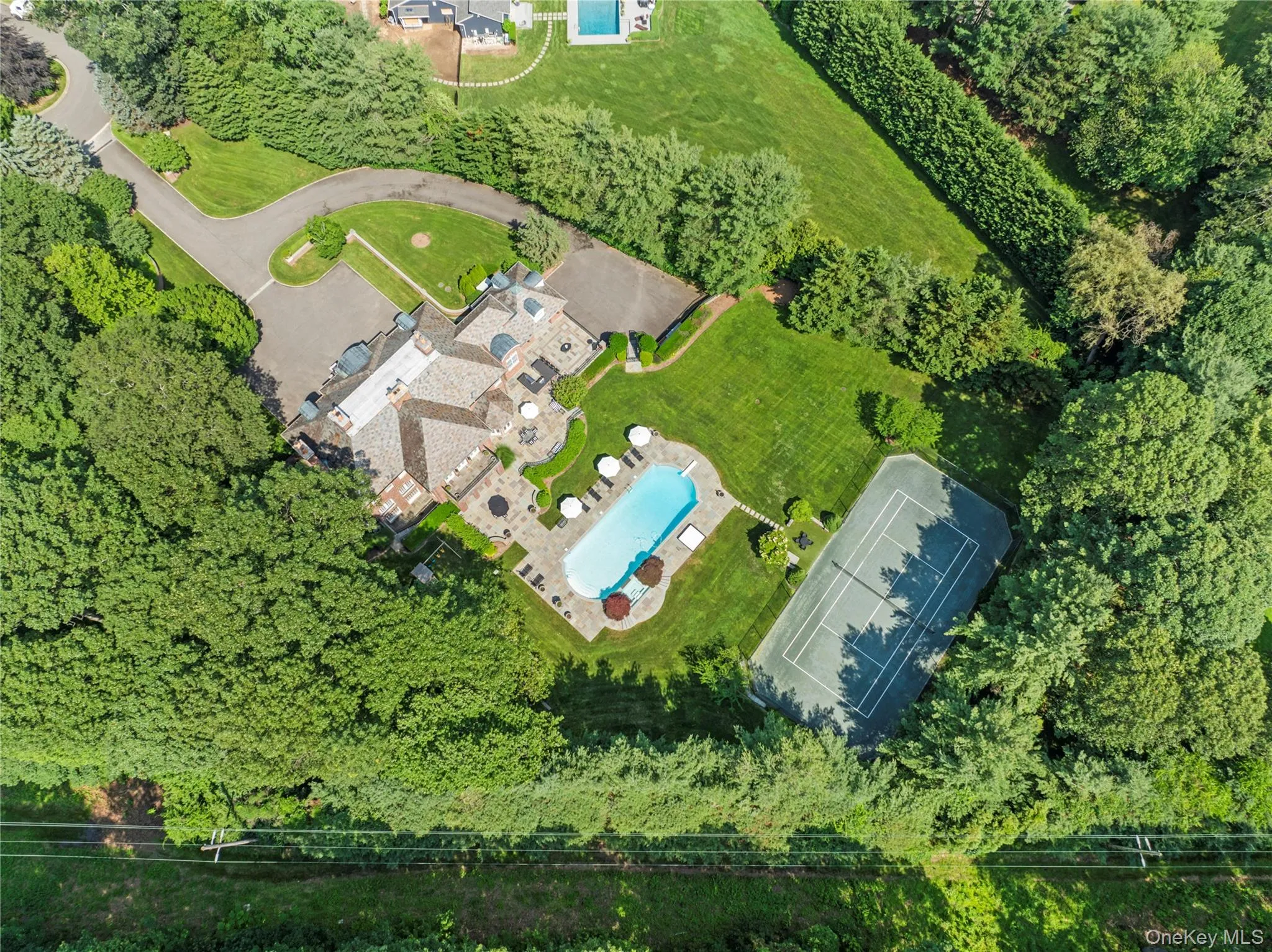 Aerial view shows expansive courtyard, brick Mansion, terraces, pool tennis Aerial view shows expansive courtyard, brick Mansion, terraces, pool tennis