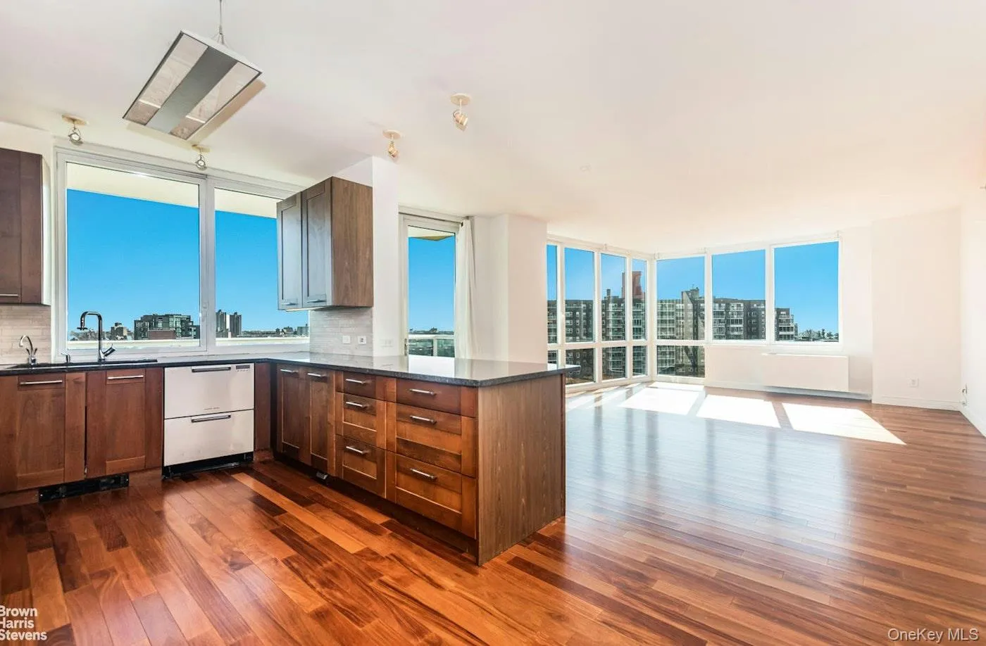 Kitchen with dishwashing machine, dark wood-style flooring, a peninsula, tasteful backsplash, and a sink Kitchen with dishwashing machine, dark wood-style flooring, a peninsula, tasteful backsplash, and a sink
