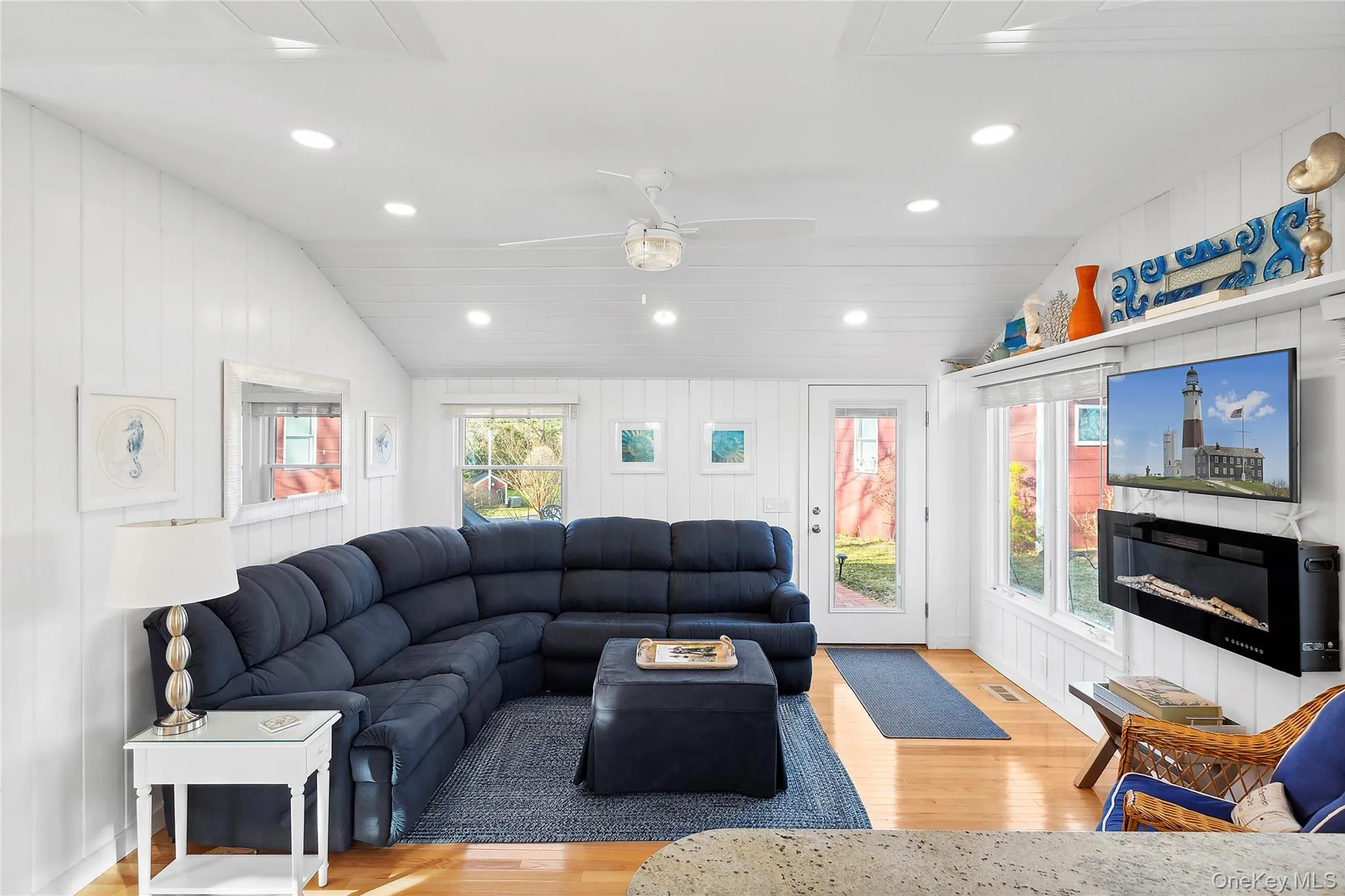 Living room featuring wood finished floors, recessed lighting, a fireplace, lofted ceiling, and a ceiling fan Living room featuring wood finished floors, recessed lighting, a fireplace, lofted ceiling, and a ceiling fan