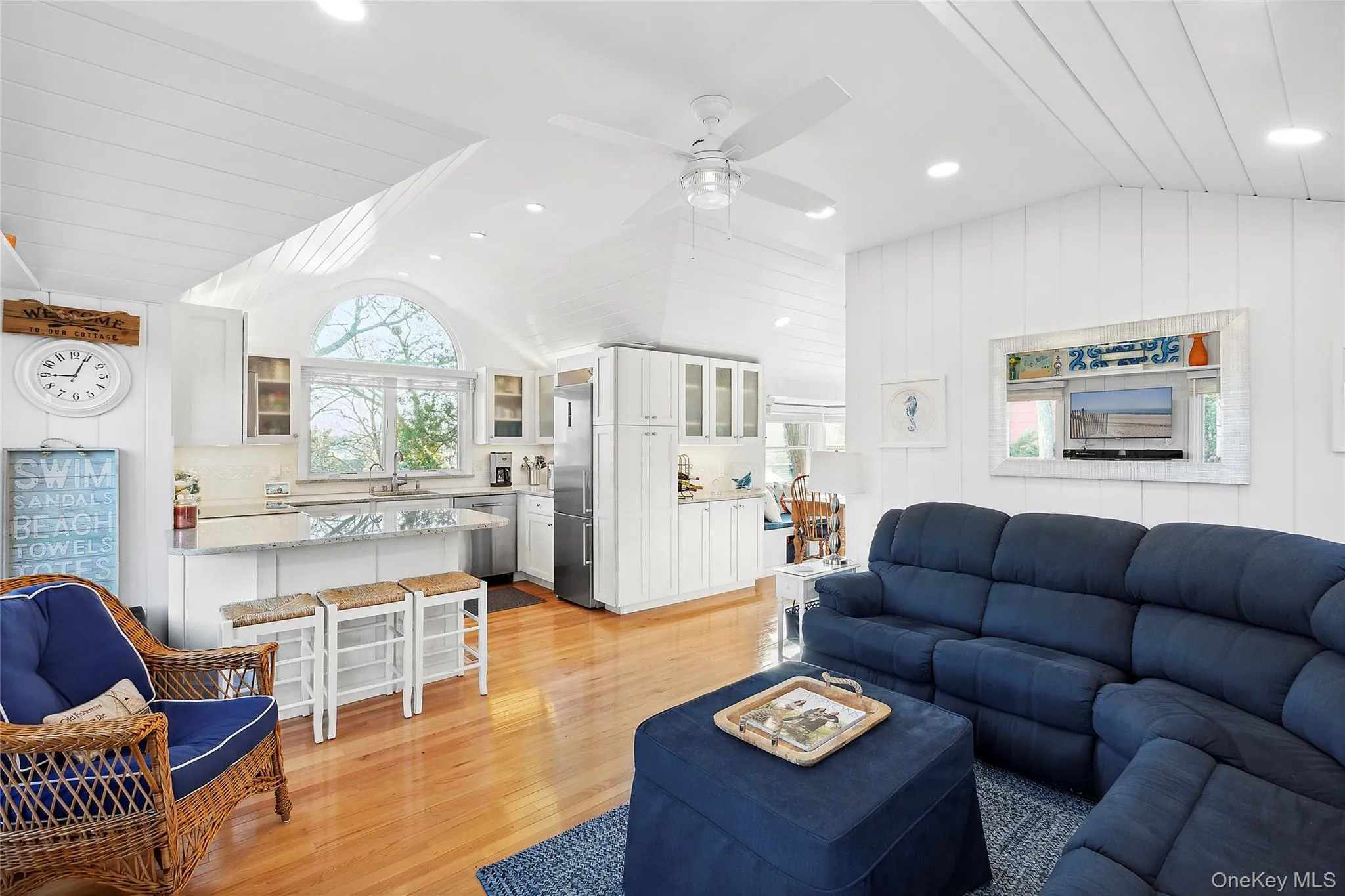Living room featuring lofted ceiling, light wood-style flooring, a ceiling fan, and recessed lighting Living room featuring lofted ceiling, light wood-style flooring, a ceiling fan, and recessed lighting
