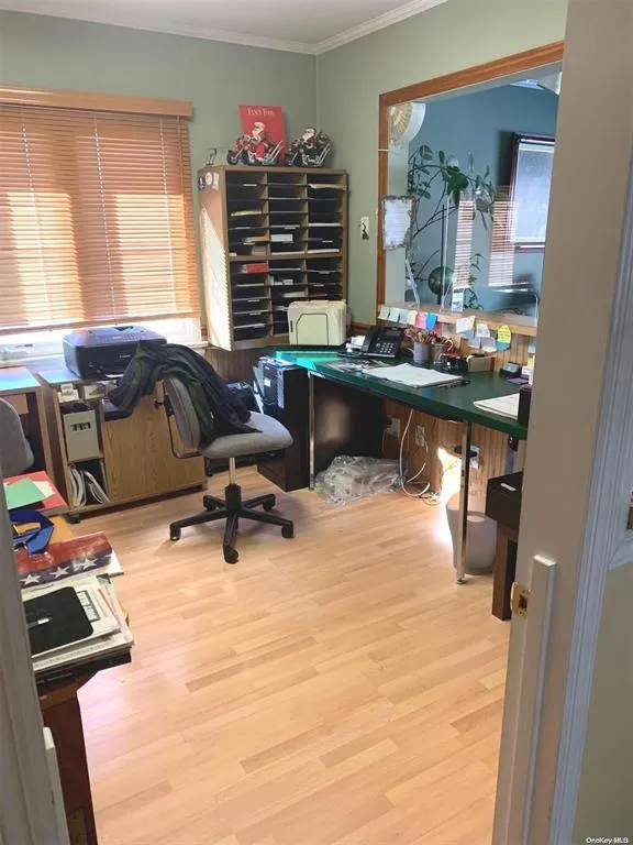 Office with ornamental molding, healthy amount of natural light, and wood finished floors Office with ornamental molding, healthy amount of natural light, and wood finished floors