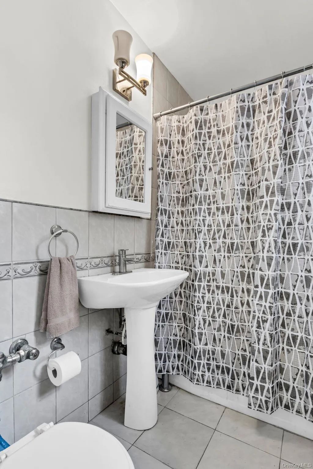 Full bath with tile walls, tile patterned flooring, toilet, a shower with shower curtain, and tasteful backsplash Full bath with tile walls, tile patterned flooring, toilet, a shower with shower curtain, and tasteful backsplash