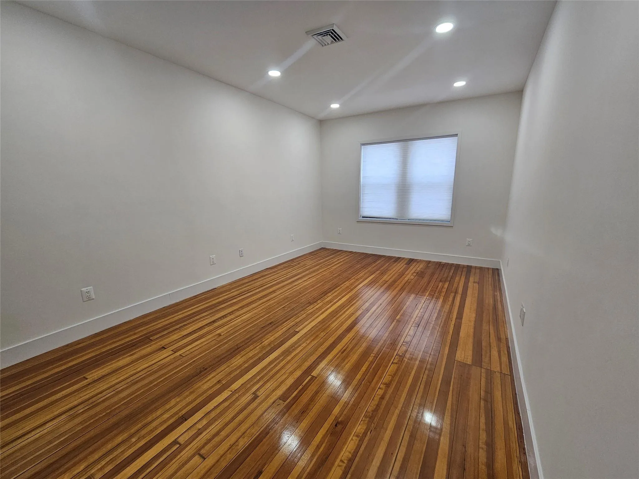 Unfurnished room featuring baseboards, hardwood / wood-style floors, and recessed lighting Unfurnished room featuring baseboards, hardwood / wood-style floors, and recessed lighting