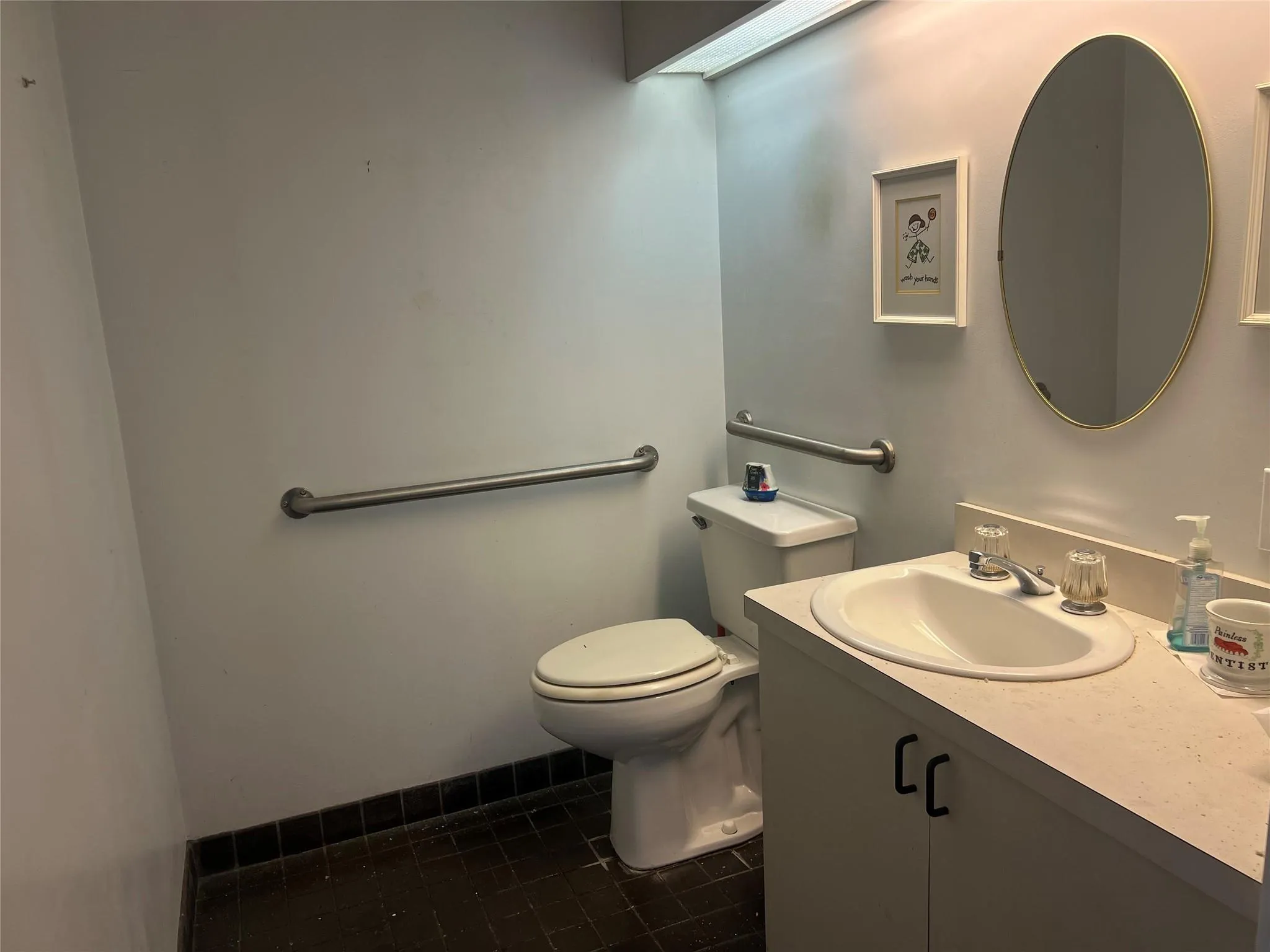 Half bath with toilet, tile patterned flooring, and vanity Half bath with toilet, tile patterned flooring, and vanity