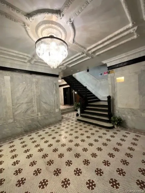 Below grade area featuring a chandelier and stairway Below grade area featuring a chandelier and stairway