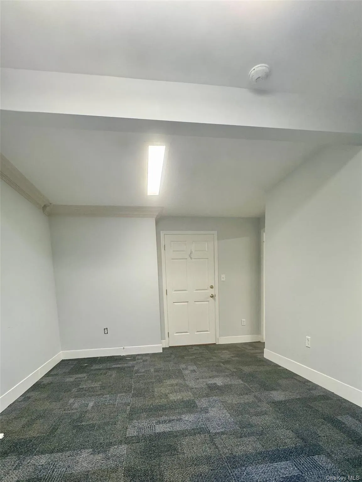 Below grade area featuring dark carpet and baseboards Below grade area featuring dark carpet and baseboards