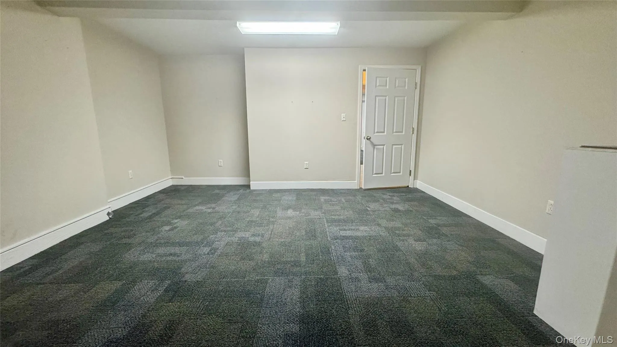 Unfurnished room with dark colored carpet and baseboards Unfurnished room with dark colored carpet and baseboards