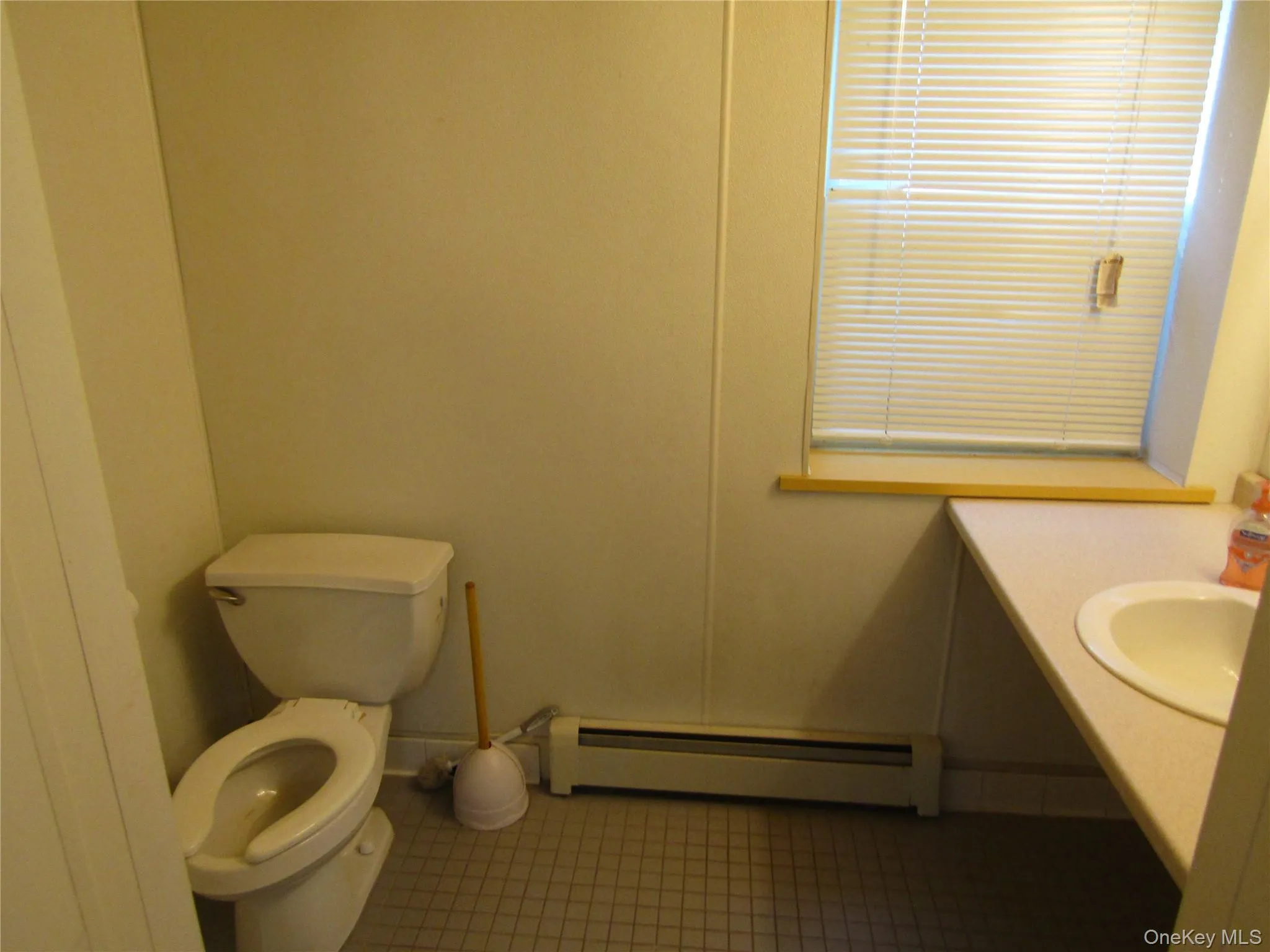 Bathroom featuring tile patterned floors, toilet, a baseboard heating unit, and sink Bathroom featuring tile patterned floors, toilet, a baseboard heating unit, and sink