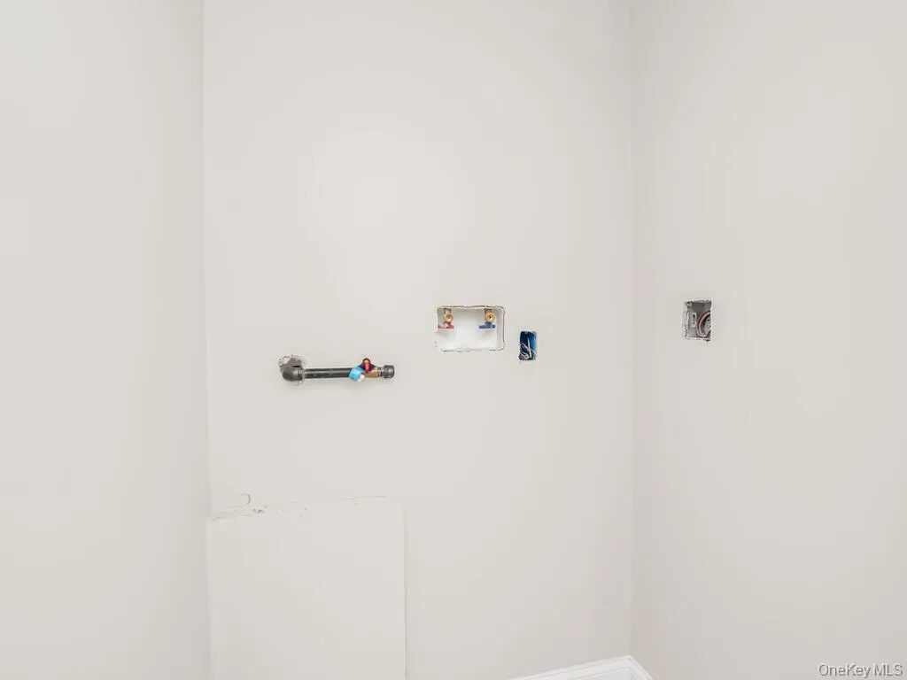 Laundry room featuring hookup for a washing machine and baseboards Laundry room featuring hookup for a washing machine and baseboards