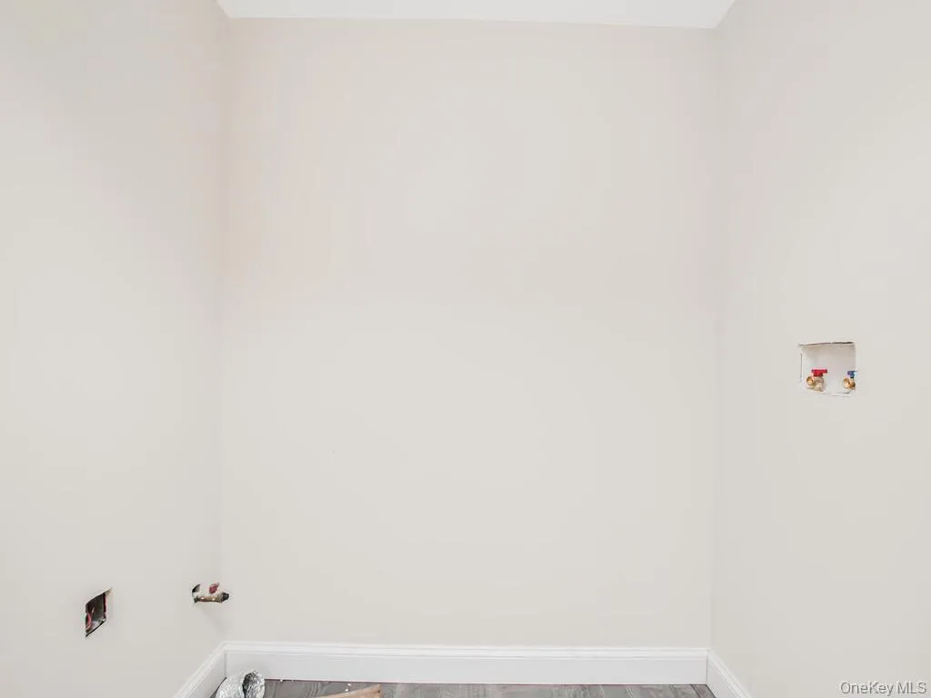 Laundry room featuring washer hookup, baseboards, wood finished floors, and hookup for a gas dryer Laundry room featuring washer hookup, baseboards, wood finished floors, and hookup for a gas dryer