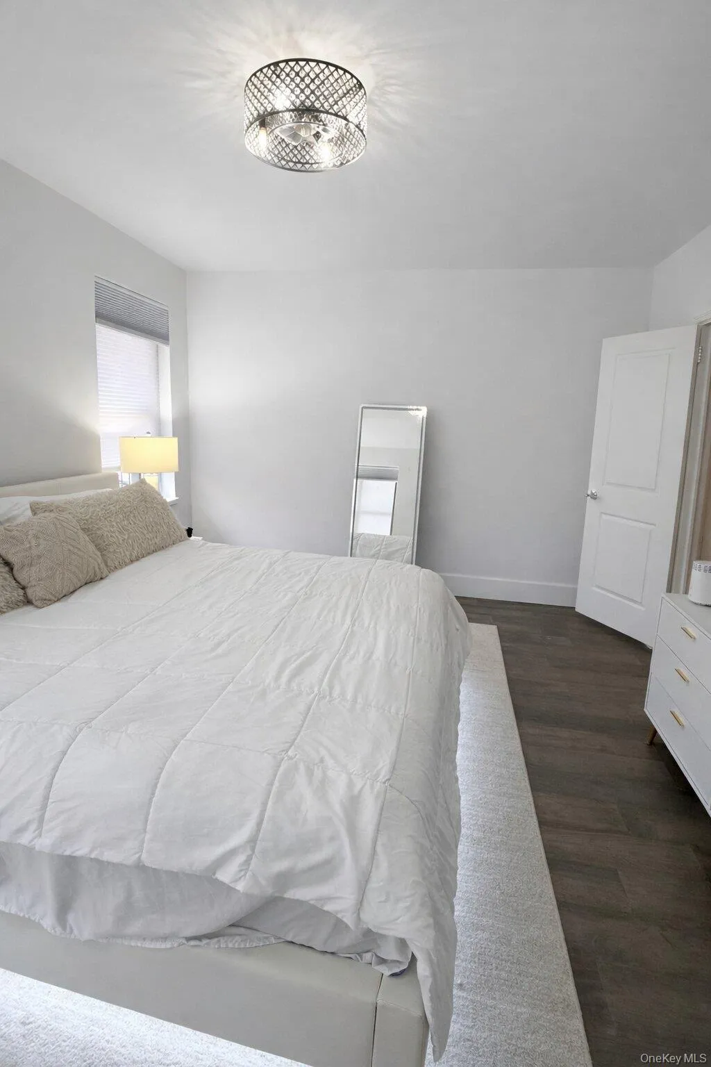 Bedroom featuring dark wood-type flooring and baseboards Bedroom featuring dark wood-type flooring and baseboards