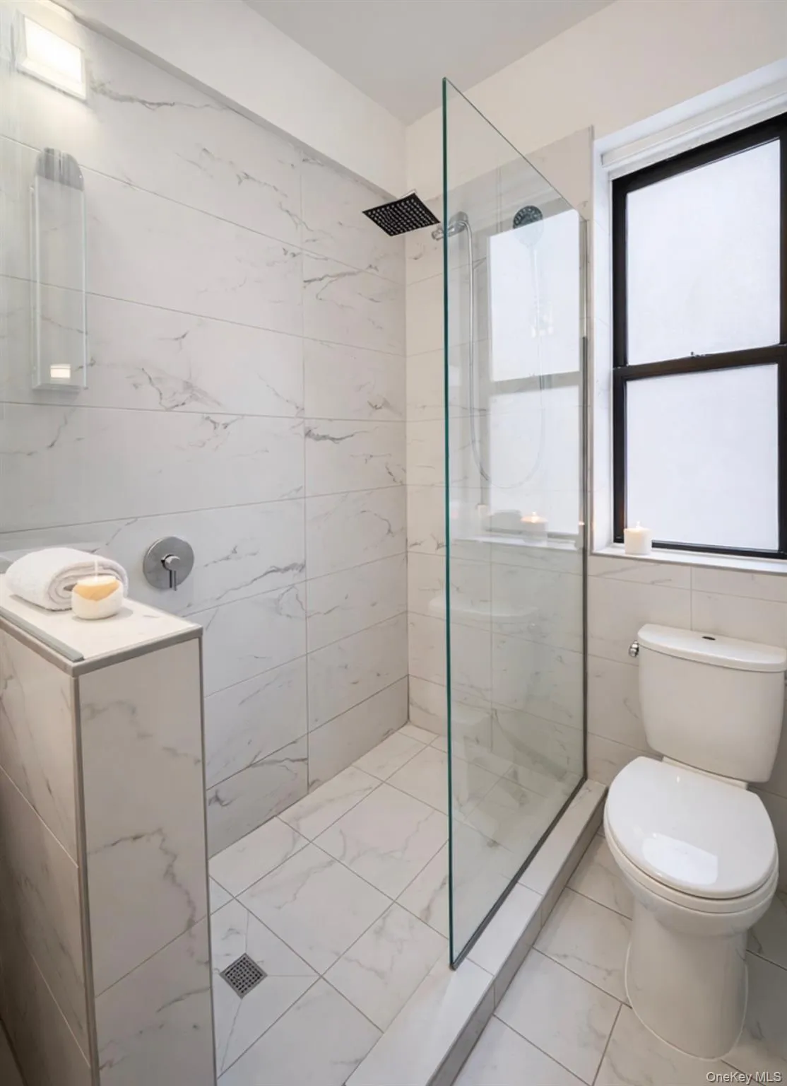 Full bathroom with walk in shower, tile walls, and light marble finish flooring Full bathroom with walk in shower, tile walls, and light marble finish flooring