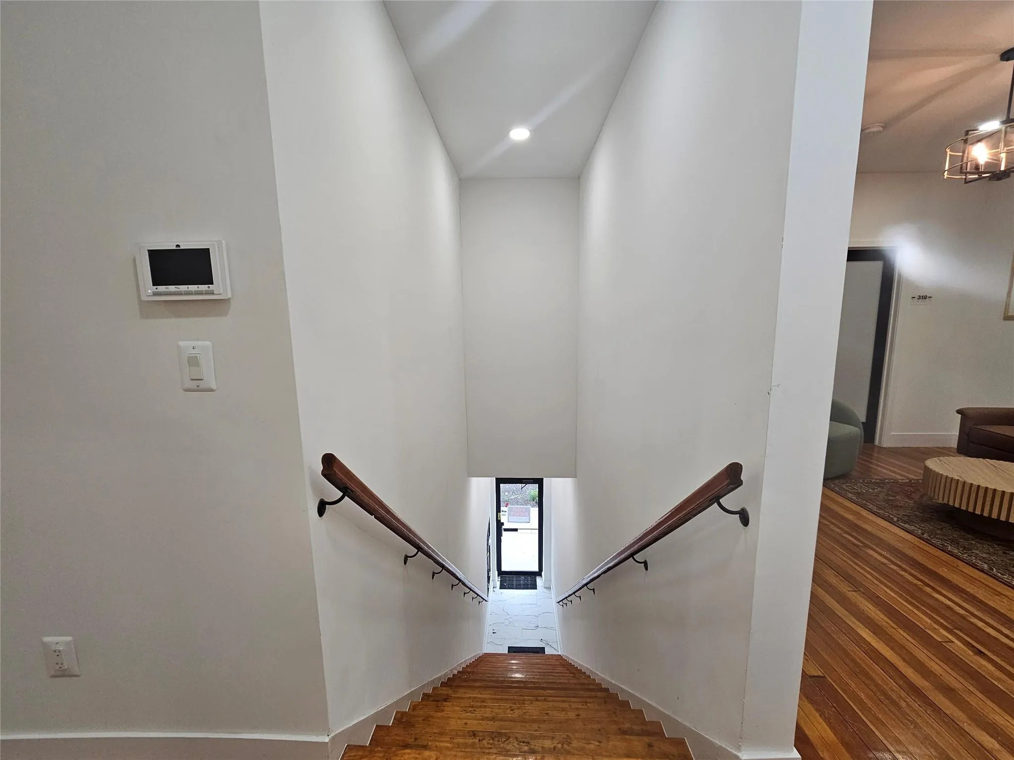 Staircase featuring wood finished floors, recessed lighting, and baseboards Staircase featuring wood finished floors, recessed lighting, and baseboards
