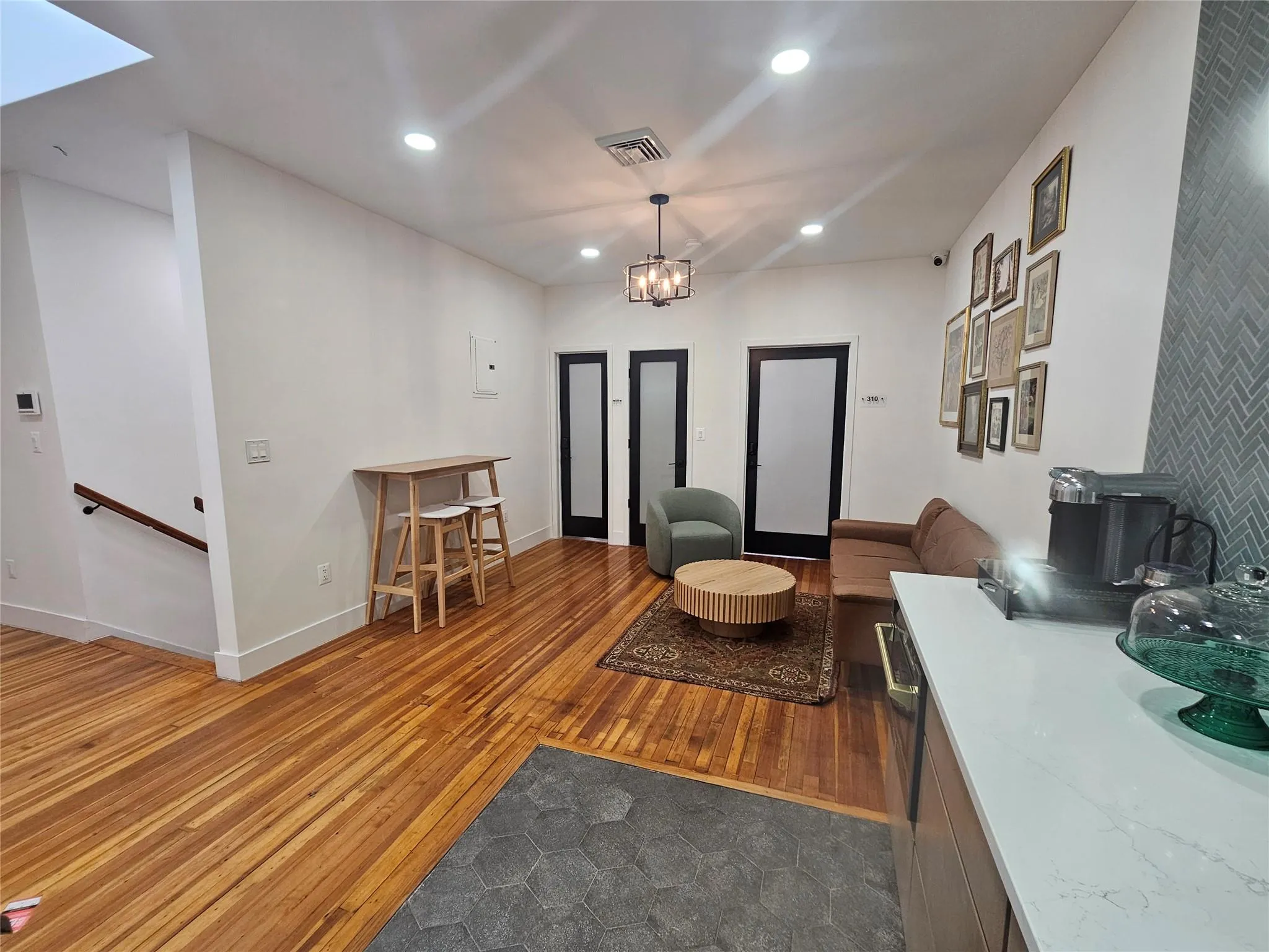 Living room with recessed lighting, hardwood / wood-style flooring, baseboards, and a chandelier Living room with recessed lighting, hardwood / wood-style flooring, baseboards, and a chandelier