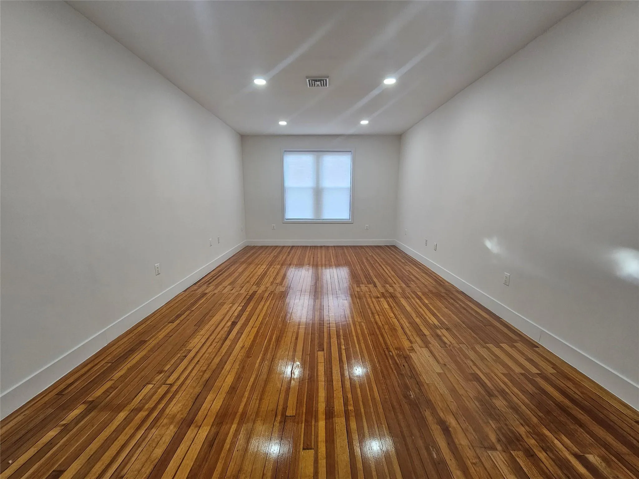 Empty room featuring hardwood / wood-style floors, baseboards, and recessed lighting Empty room featuring hardwood / wood-style floors, baseboards, and recessed lighting