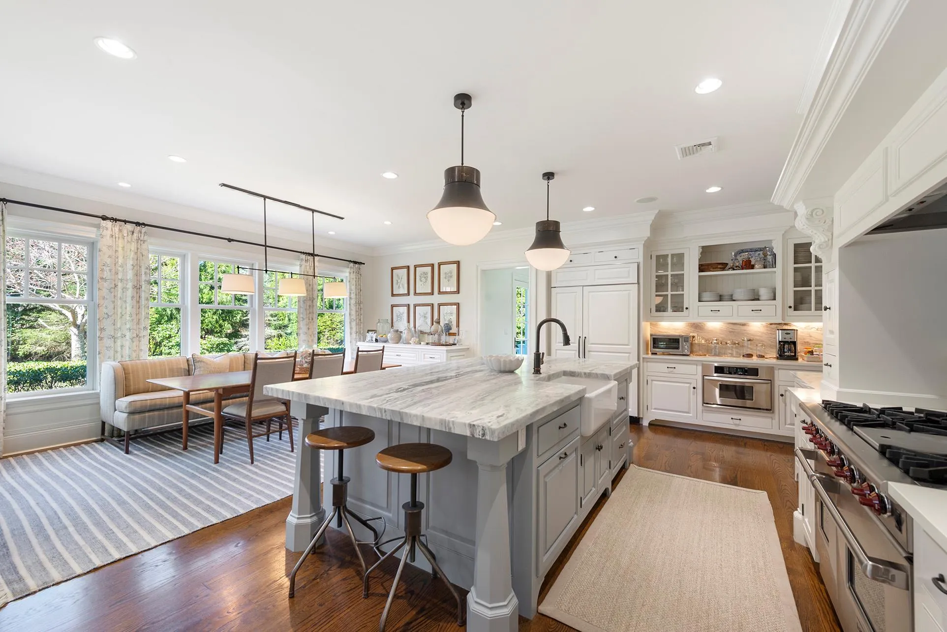 Kitchen featuring a sink, oven, plenty of natural light, white cabinetry, and ornamental molding Kitchen featuring a sink, oven, plenty of natural light, white cabinetry, and ornamental molding