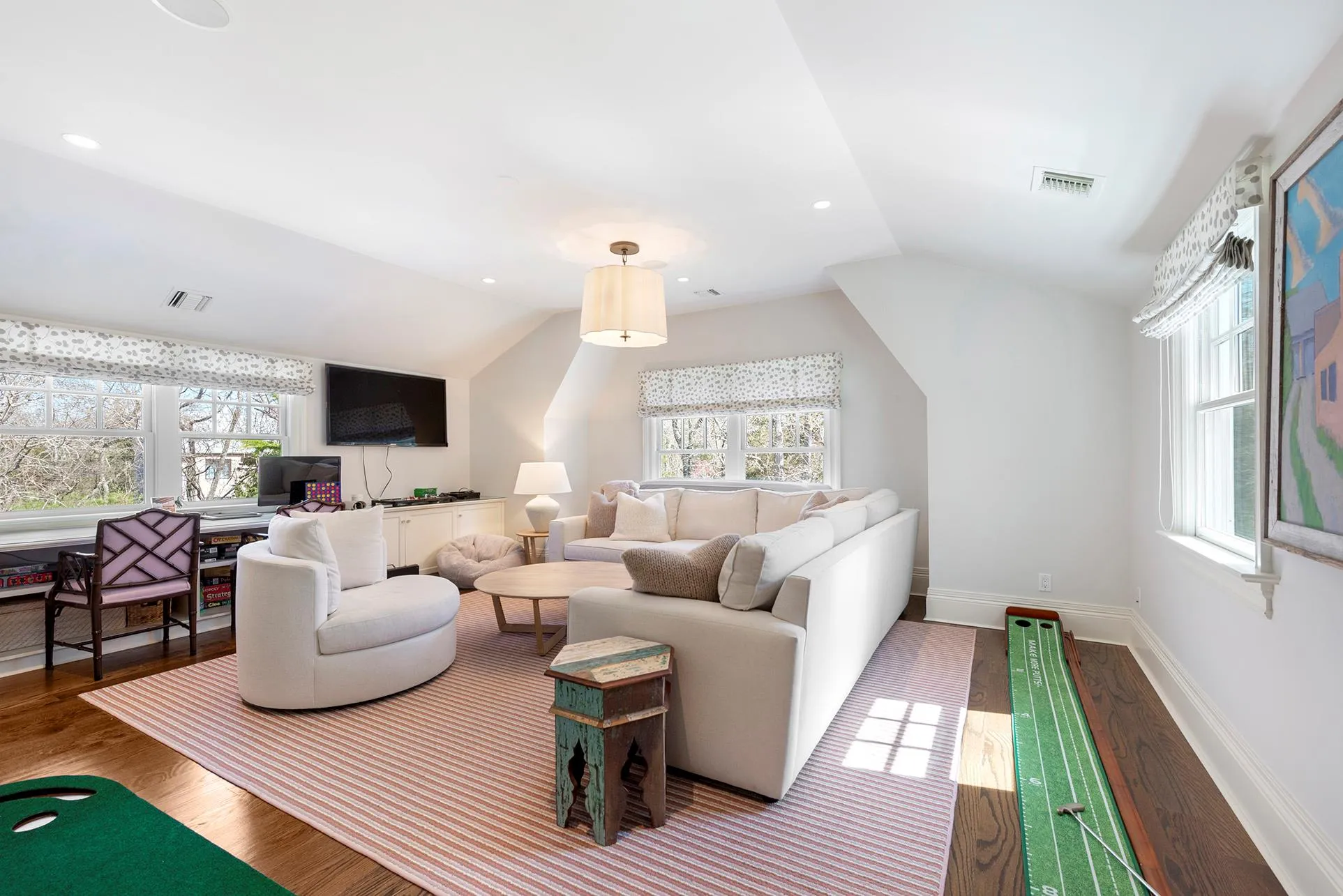 Living area featuring vaulted ceiling, healthy amount of natural light, a desk, and wood finished floors Living area featuring vaulted ceiling, healthy amount of natural light, a desk, and wood finished floors