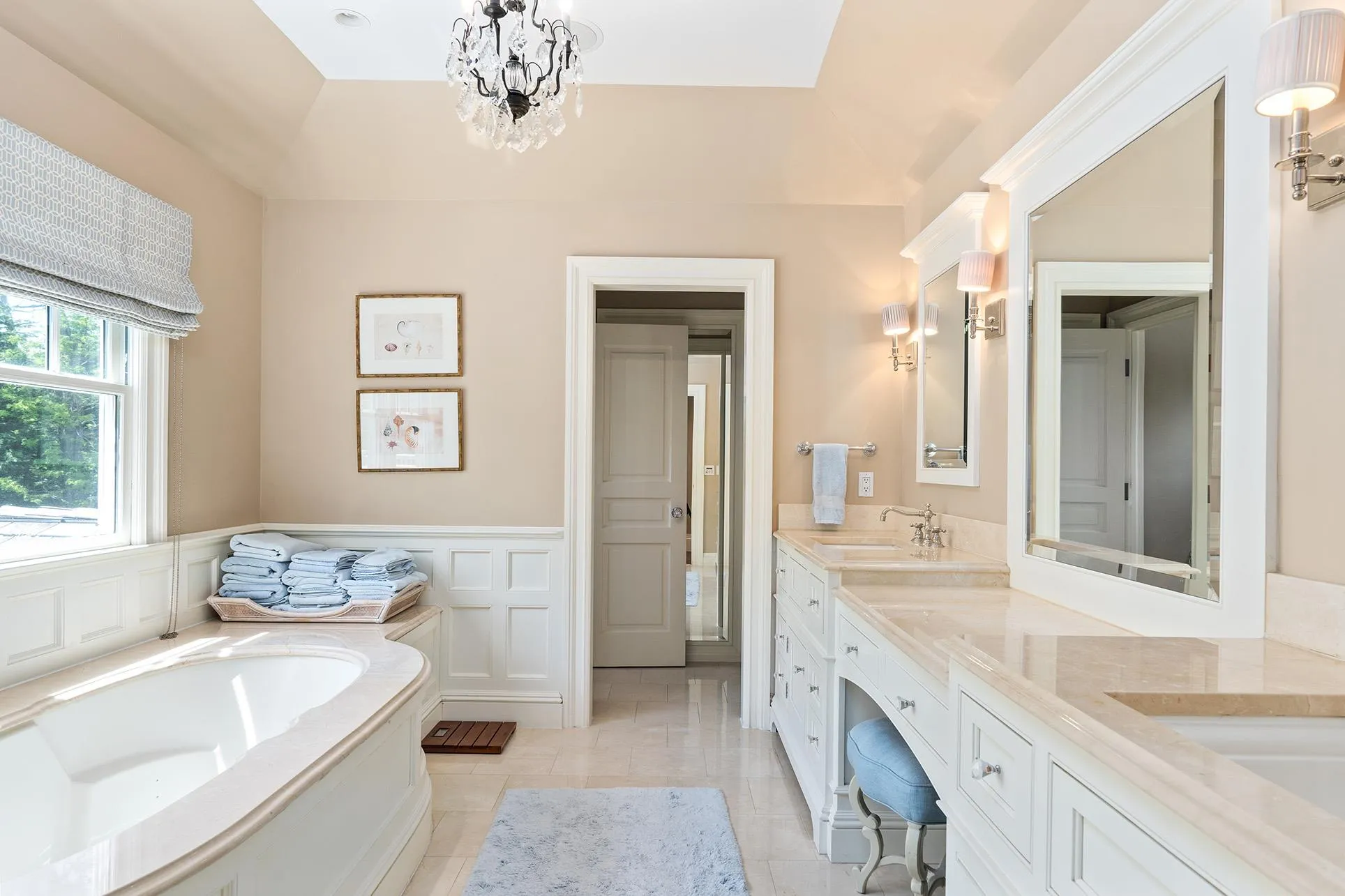 Bathroom featuring double vanity, a bath, a wainscoted wall, tile patterned floors, and a chandelier Bathroom featuring double vanity, a bath, a wainscoted wall, tile patterned floors, and a chandelier