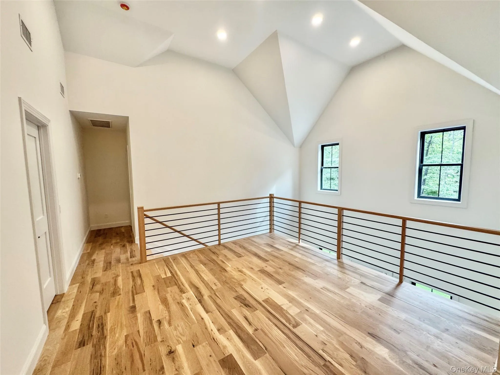 Additional living space featuring light wood-style floors, recessed lighting, and high vaulted ceiling Additional living space featuring light wood-style floors, recessed lighting, and high vaulted ceiling