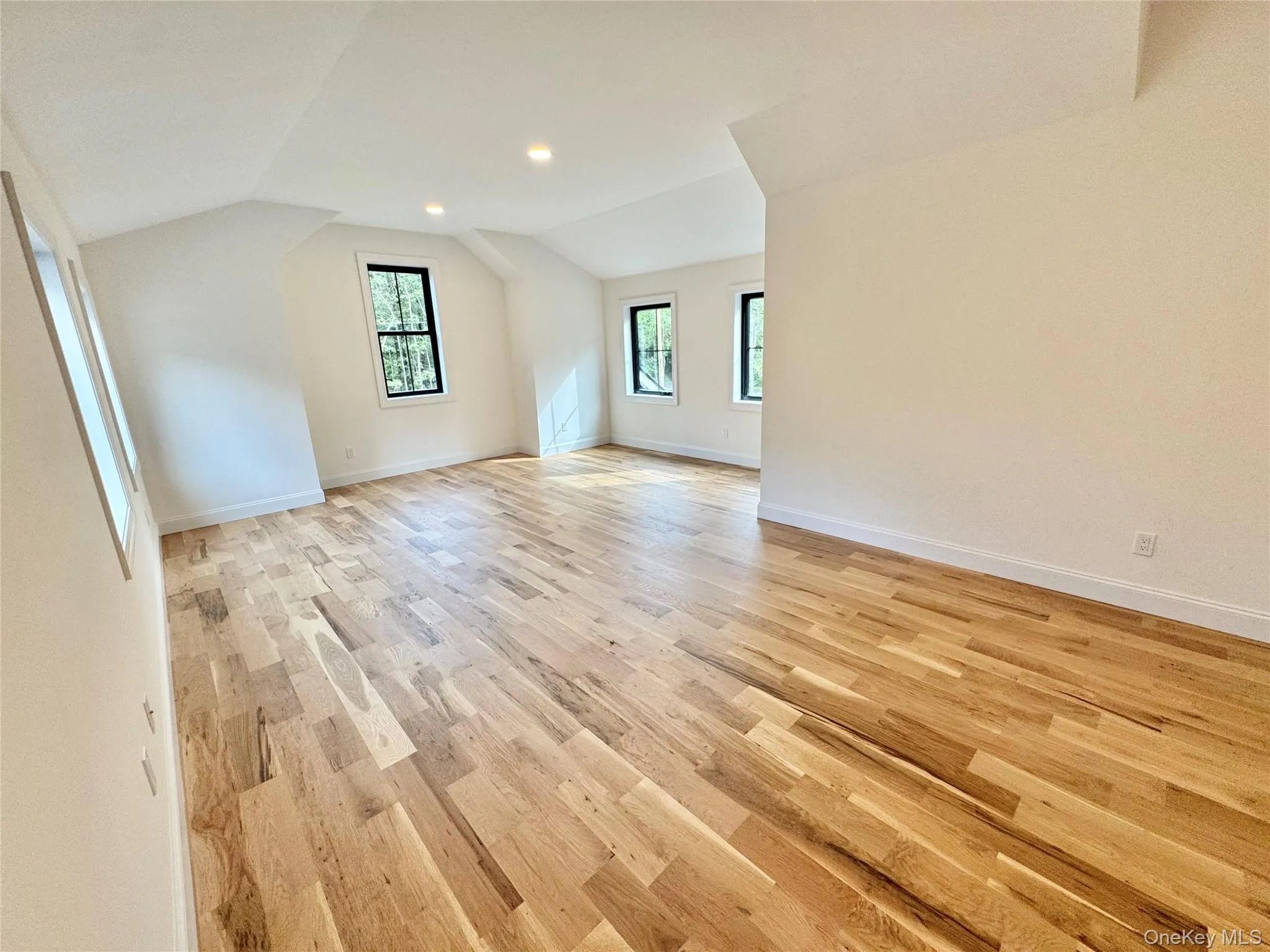 Additional living space with light wood-type flooring, vaulted ceiling, and recessed lighting Additional living space with light wood-type flooring, vaulted ceiling, and recessed lighting