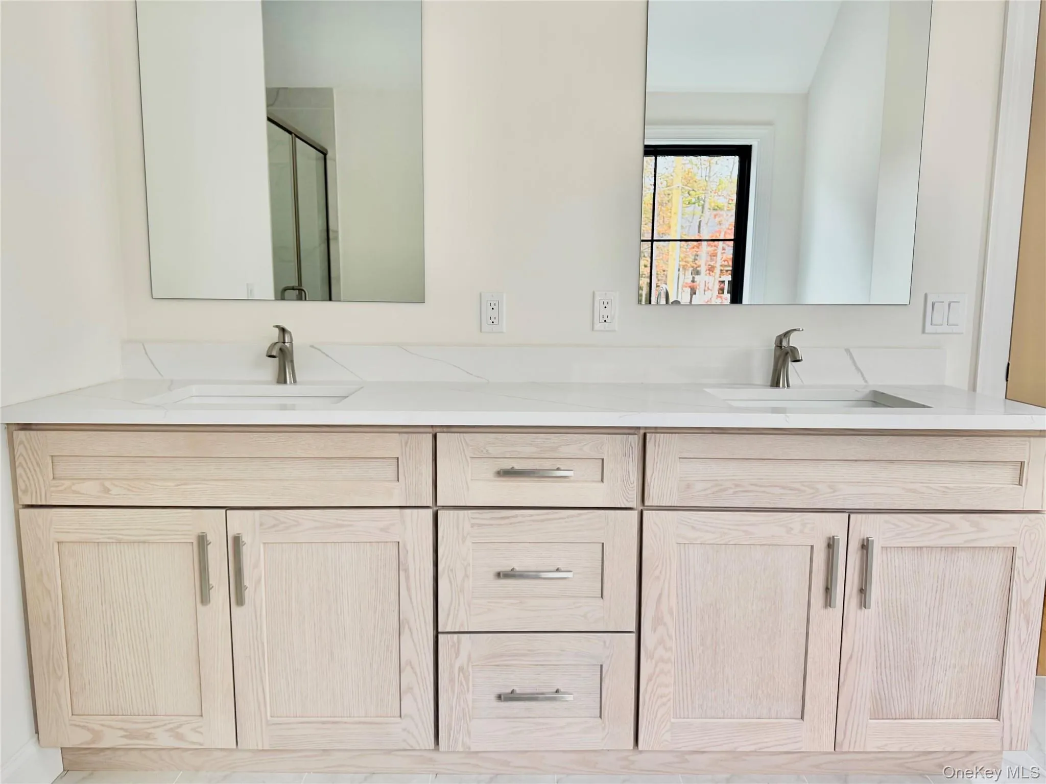 Bathroom featuring double vanity and a shower stall Bathroom featuring double vanity and a shower stall