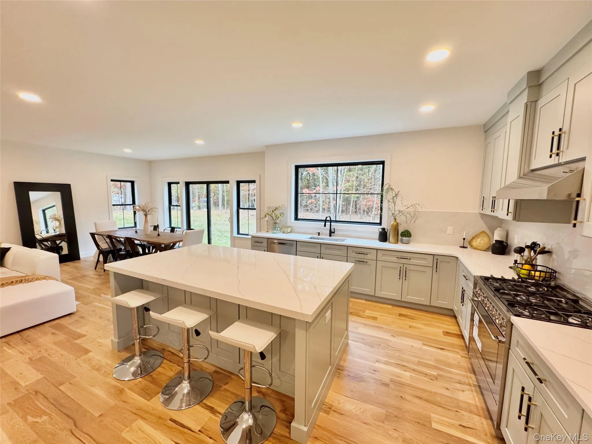 Kitchen with stainless steel appliances, decorative backsplash, recessed lighting, a center island, and light wood-style floors Kitchen with stainless steel appliances, decorative backsplash, recessed lighting, a center island, and light wood-style floors