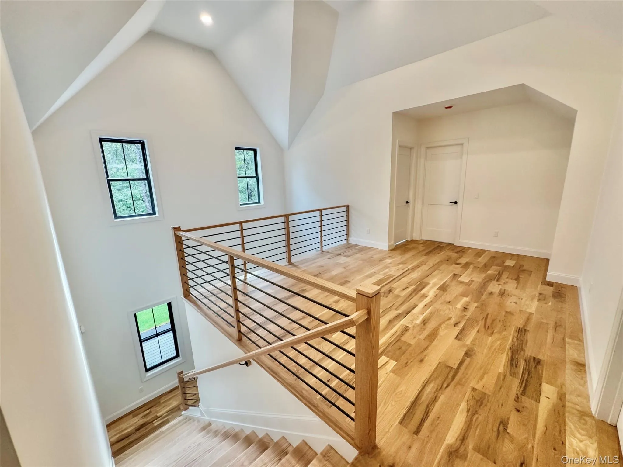 Bonus room featuring light wood-type flooring and high vaulted ceiling Bonus room featuring light wood-type flooring and high vaulted ceiling