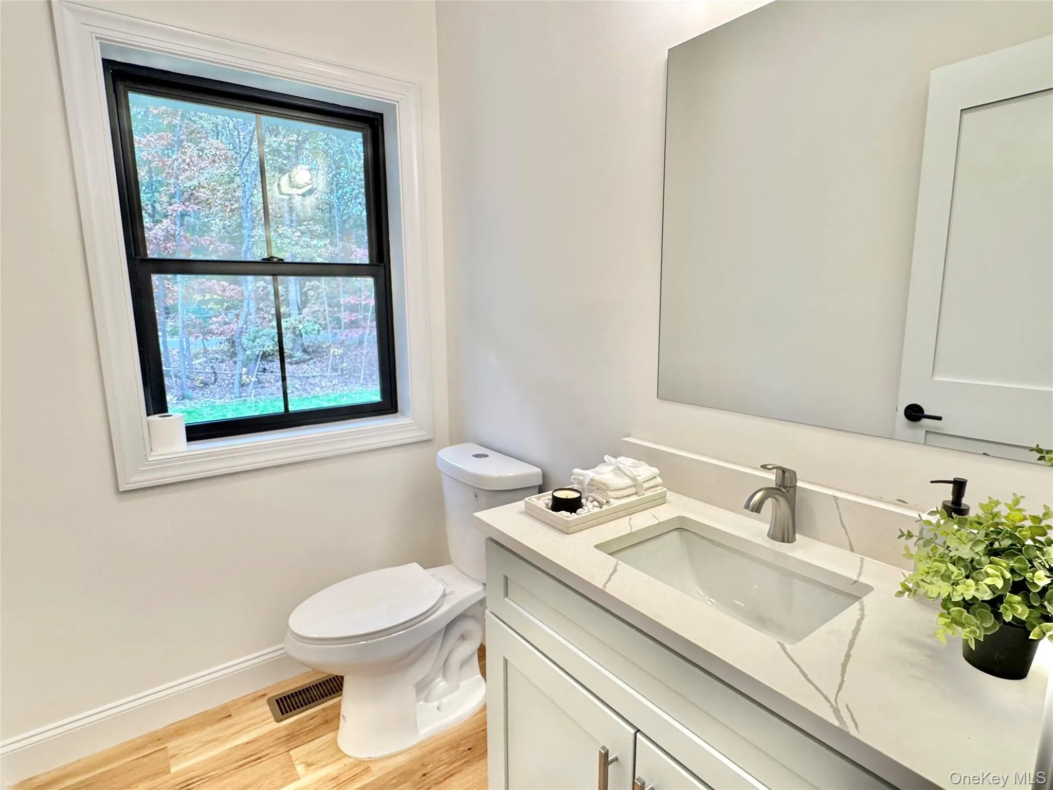Half bath featuring vanity and light wood-style flooring Half bath featuring vanity and light wood-style flooring