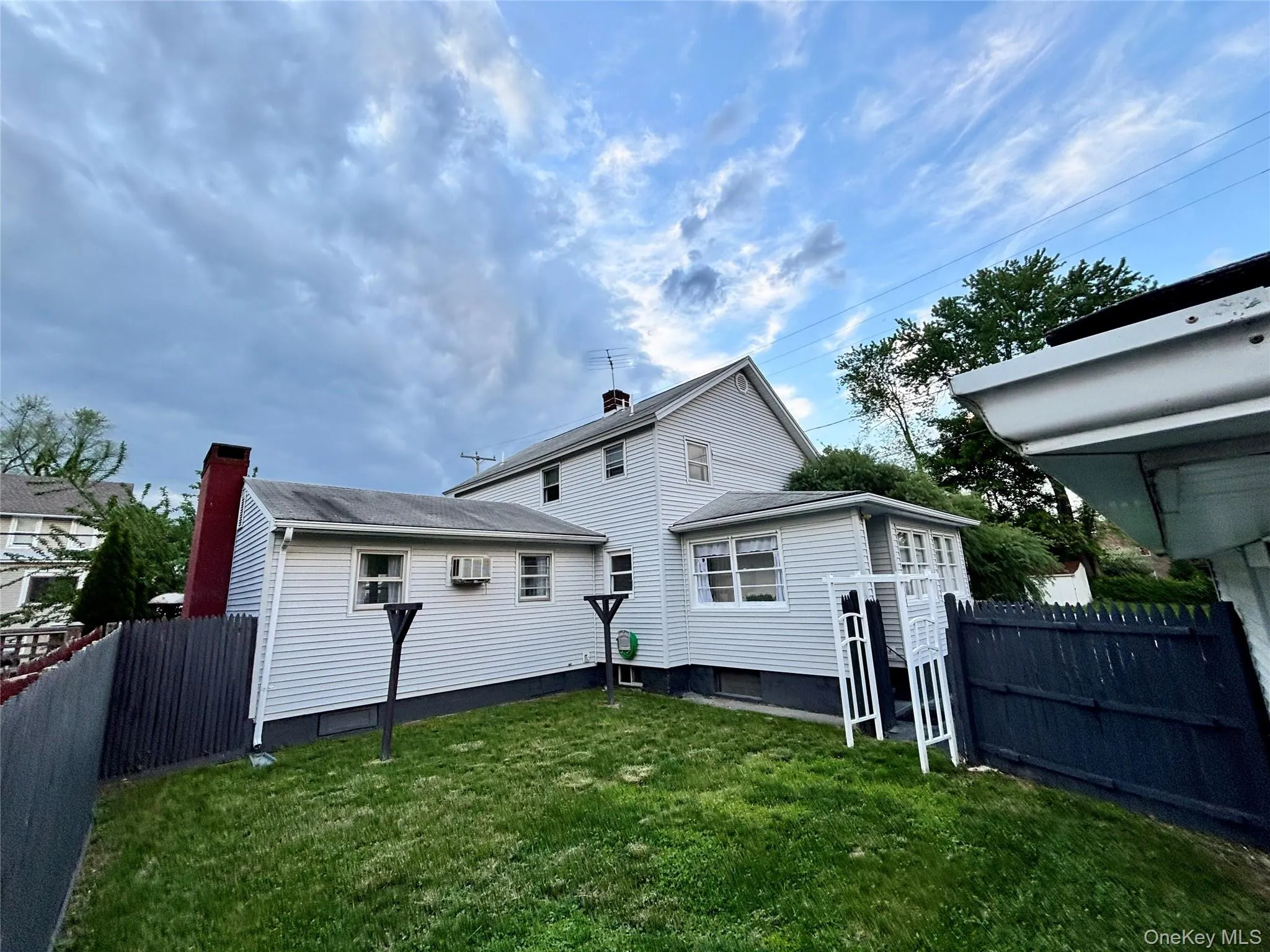 Rear view of property with an outbuilding and a wall mounted air conditioner Rear view of property with an outbuilding and a wall mounted air conditioner