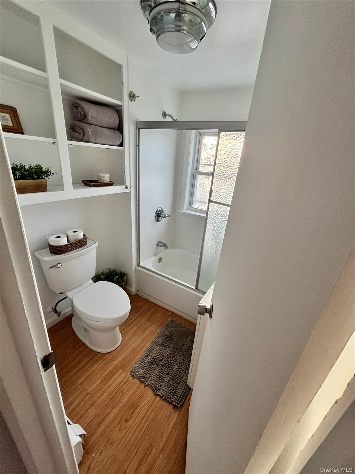 Full bath with toilet, wood finished floors, and tub / shower combination Full bath with toilet, wood finished floors, and tub / shower combination