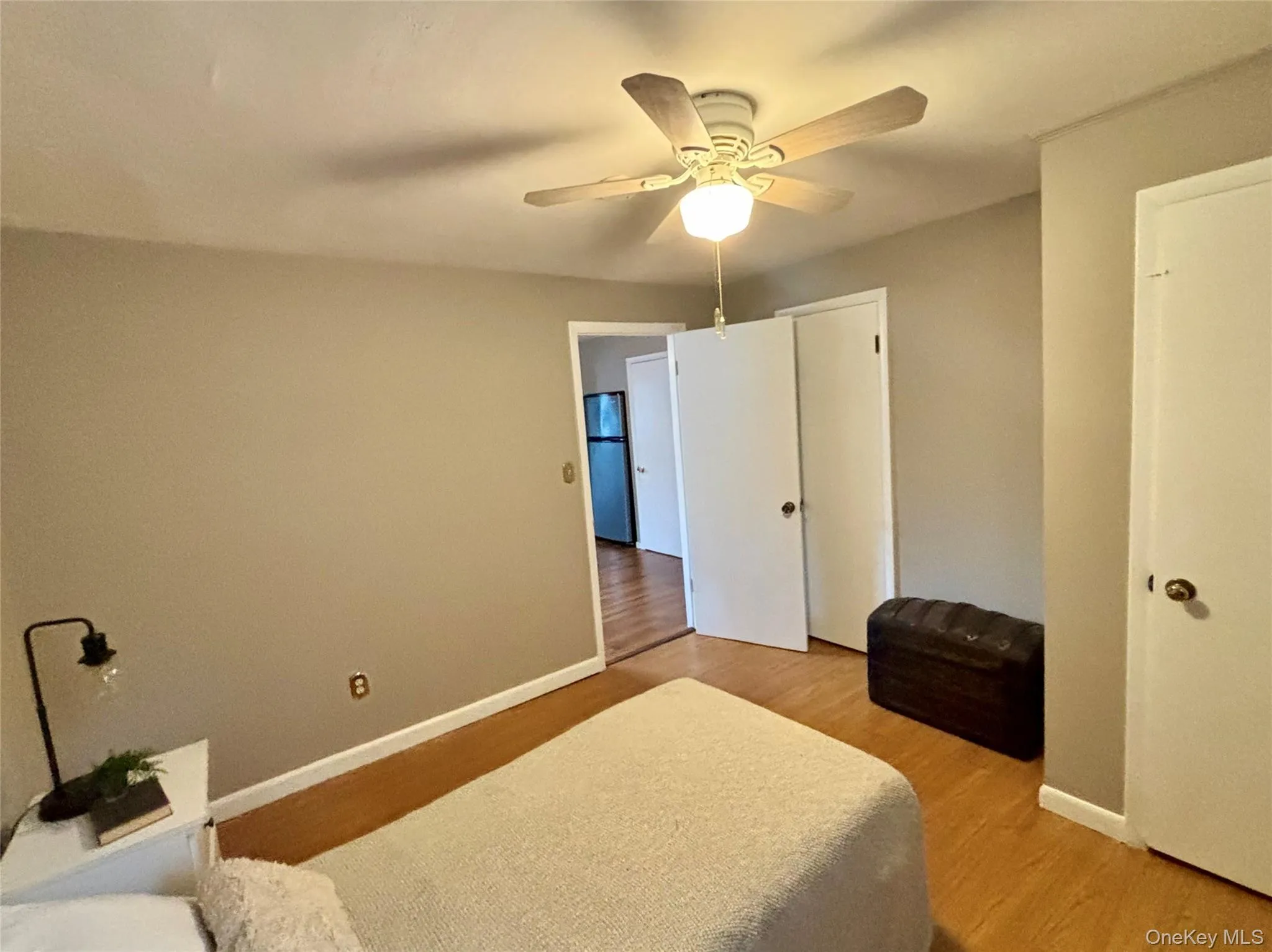 Bedroom featuring light wood-type flooring, baseboards, and a ceiling fan Bedroom featuring light wood-type flooring, baseboards, and a ceiling fan