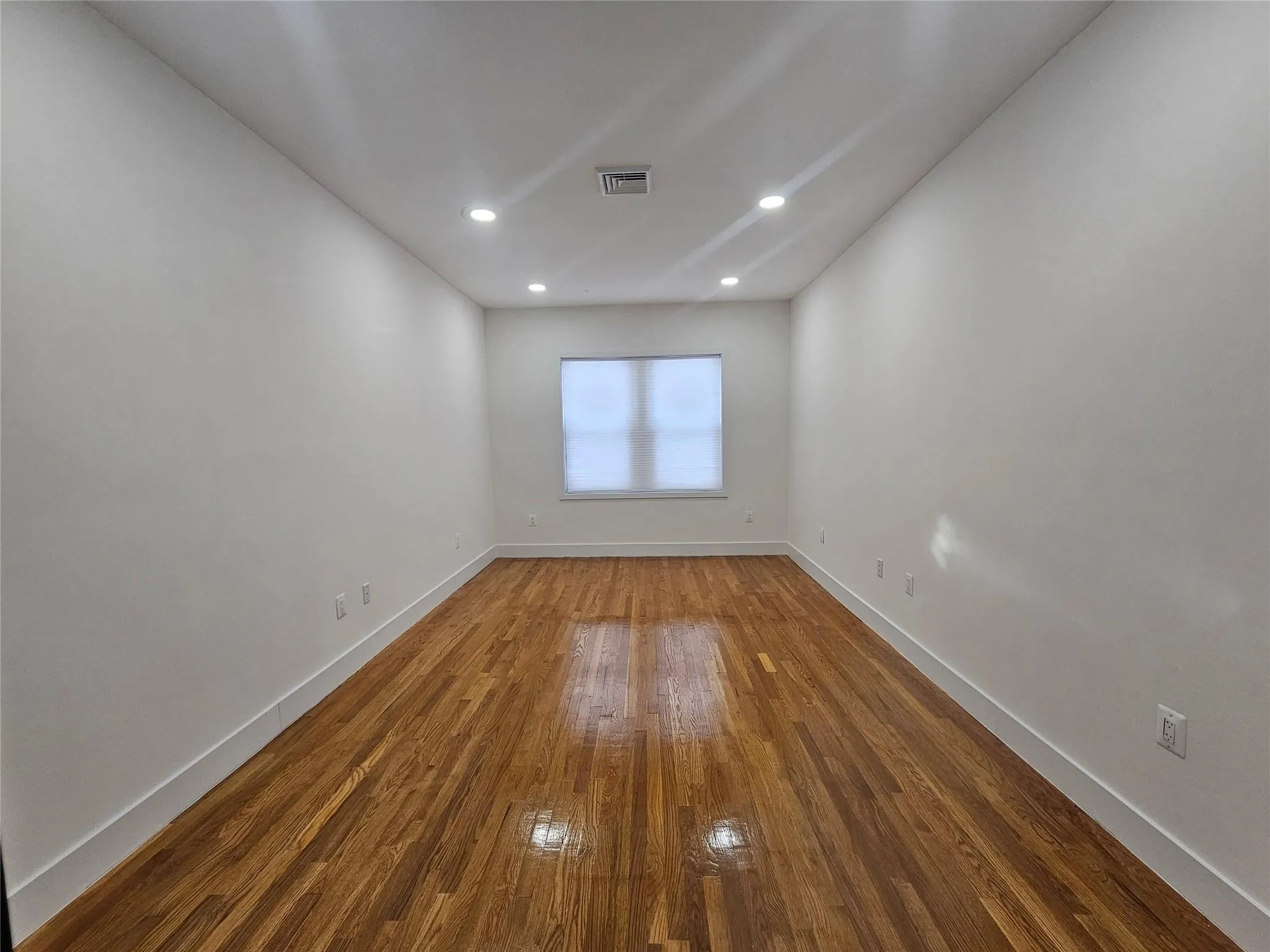Unfurnished room with wood finished floors, baseboards, and recessed lighting Unfurnished room with wood finished floors, baseboards, and recessed lighting