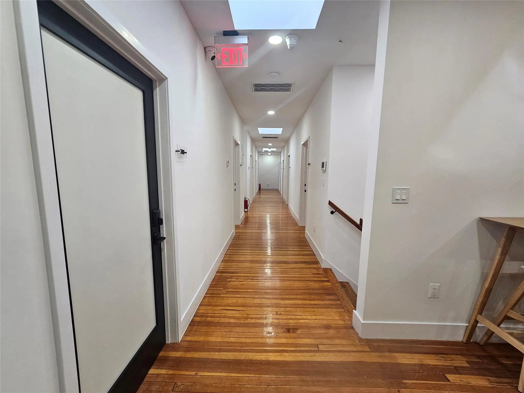 Hall with hardwood / wood-style floors, recessed lighting, baseboards, and a skylight Hall with hardwood / wood-style floors, recessed lighting, baseboards, and a skylight