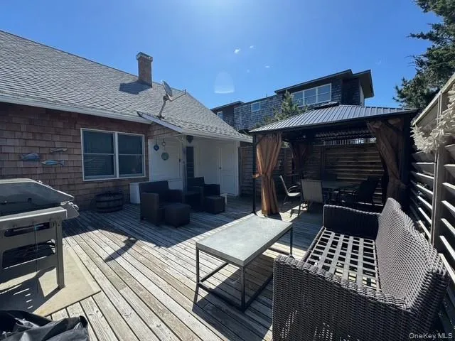 Wooden deck featuring a gazebo, an outdoor hangout area, outdoor dining space, and a grill Wooden deck featuring a gazebo, an outdoor hangout area, outdoor dining space, and a grill